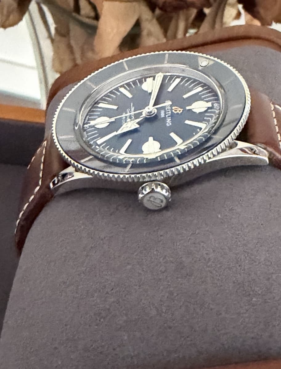 Angled close-up of a Breitling Superocean Heritage '57 on a brown leather strap