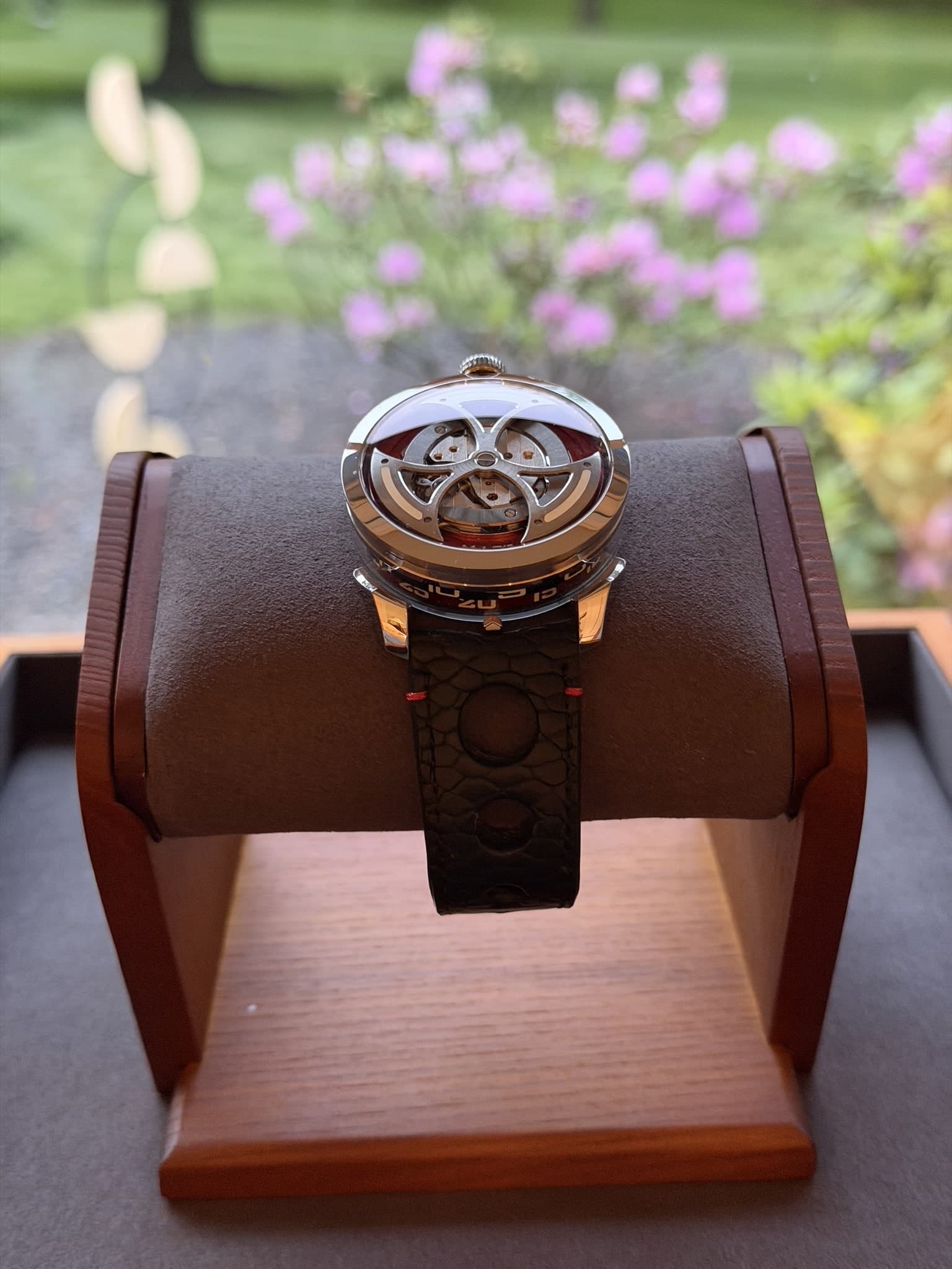 M.A.D. 1 side view on a watch stand with garden background