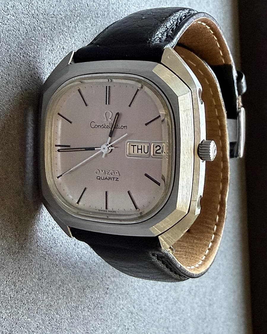 Angled view of the 1976 Omega Constellation Megaquartz day-date showing the faceted case and black leather strap